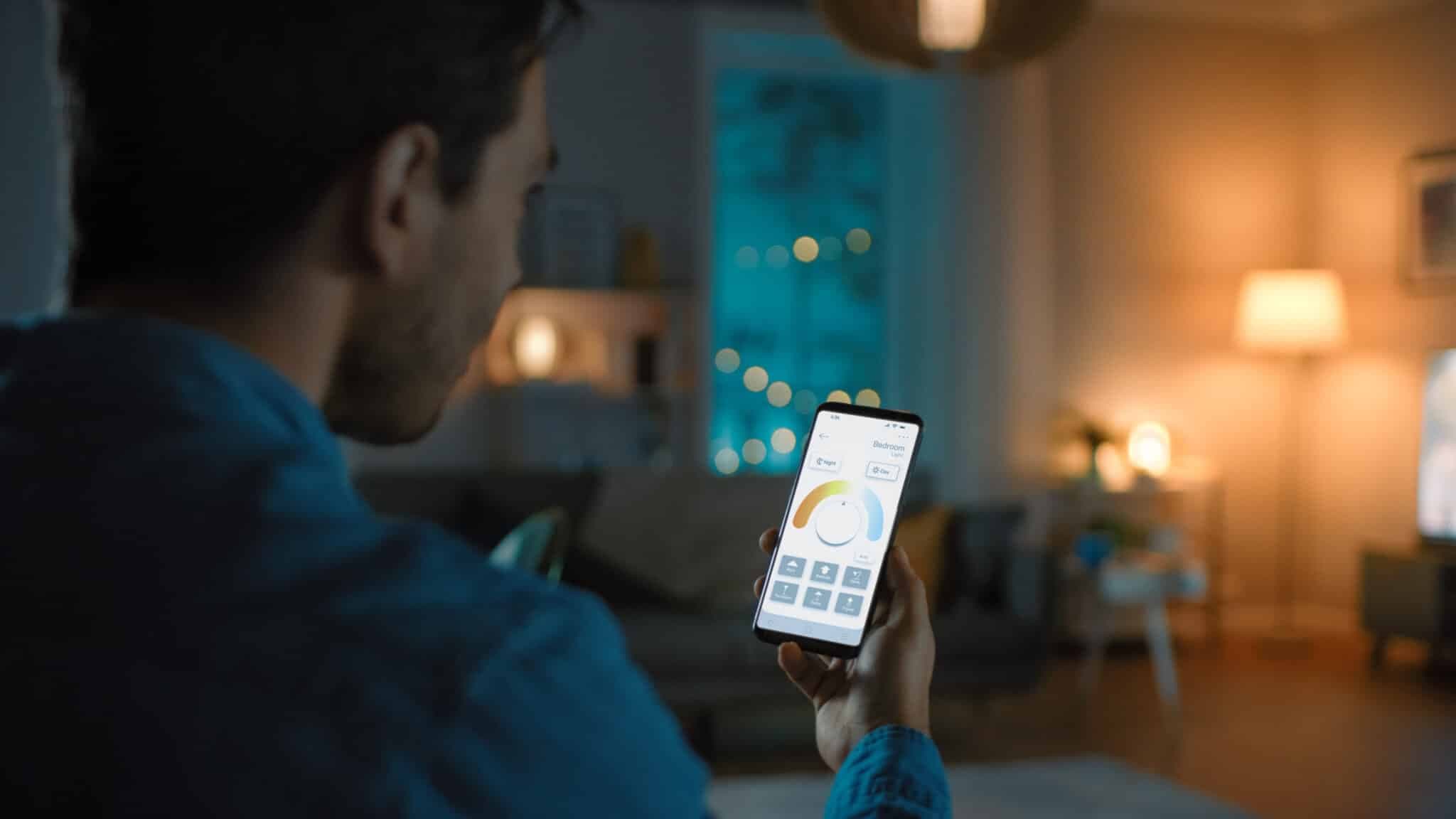 A person controlling smart home lighting using a mobile phone app