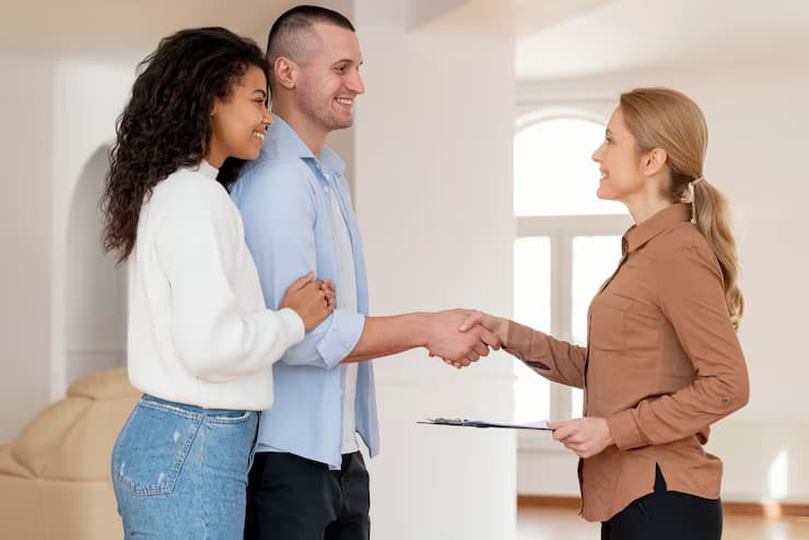 A tenant and landlord shaking hands and smiling after a good conversation