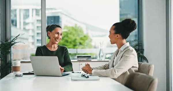 Two people having a calm and friendly discussion over a document at a table