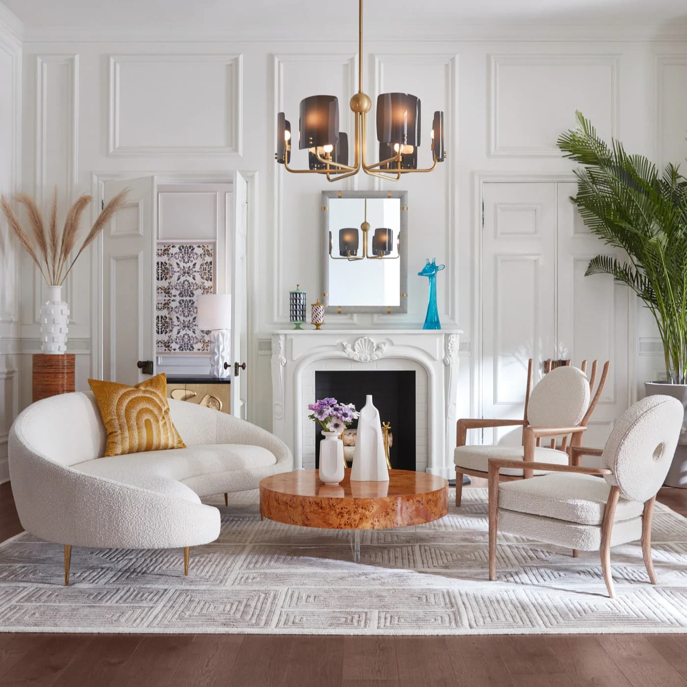 A contemporary room featuring a curved sofa, textured wallpaper, and trendy decorative vases