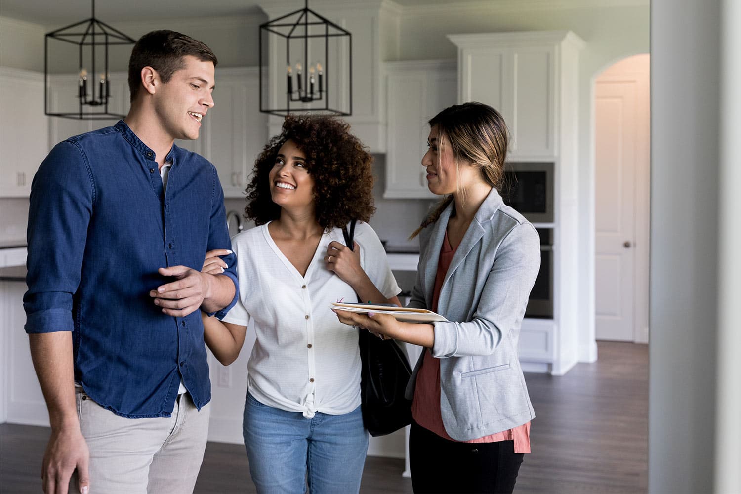 A couple talking to a landlord while viewing a house together