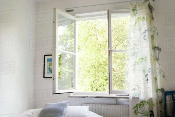 A bright room with an open window allowing fresh air and sunlight to enter the living space