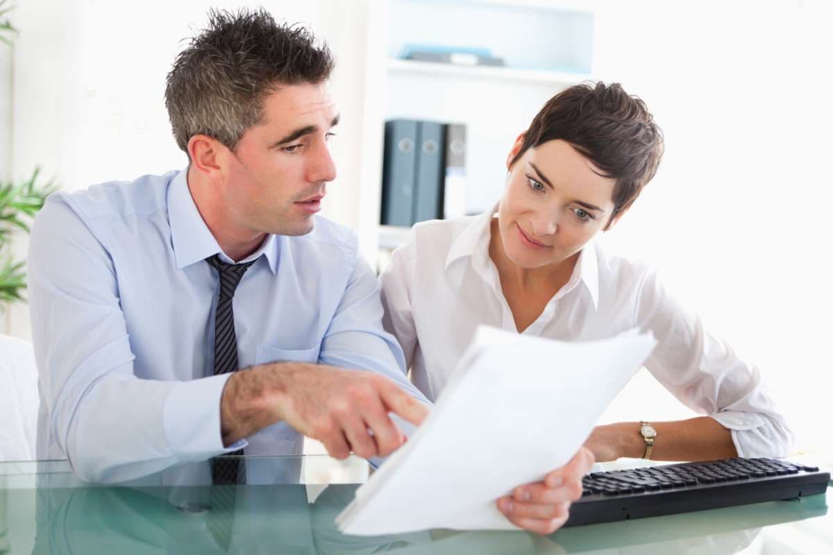 A tenant and landlord reviewing documents and discussing lease terms