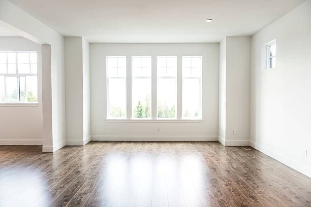Empty bright unfurnished rental room with clean walls and natural light